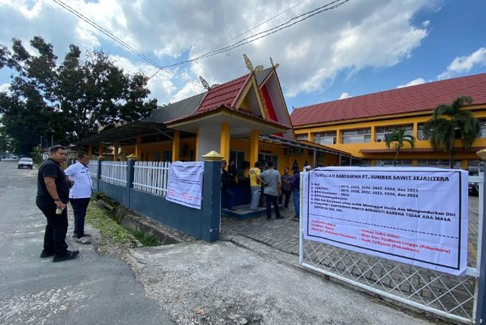 Karyawan PKS di Pelalawan mendatangi dan memasang spanduk di kantor Disnakertrans Riau, Rabu (28/5/2025).