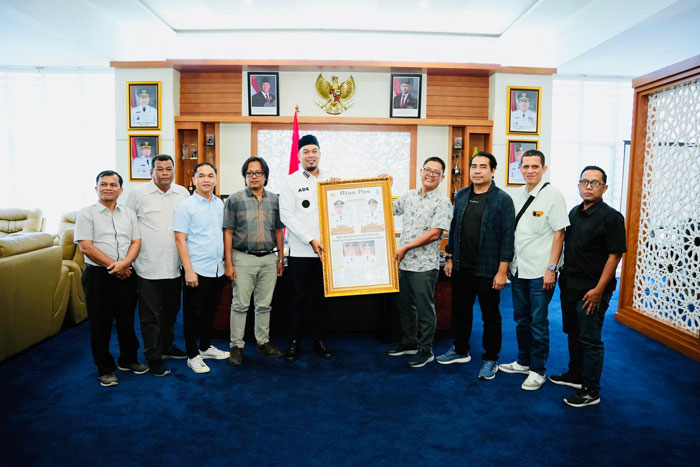 Bupati Inhu, Ade Agus Hartanto saat menerima cedera dari Riau Pos yang diserahkan CEO Riau Pos Group Ahmad Dardiri, Rabu (28/5/2025).