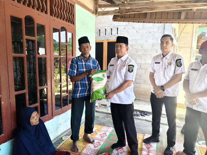 Wabup Rohul H Syafaruddin Poti SH MM menyerahkan bantuan dari Pemkab Rohul kepada korban kebakaran rumah di Desa Tangun, Kecamatan Bangun Purba, Rabu (28/5/2025) siang.