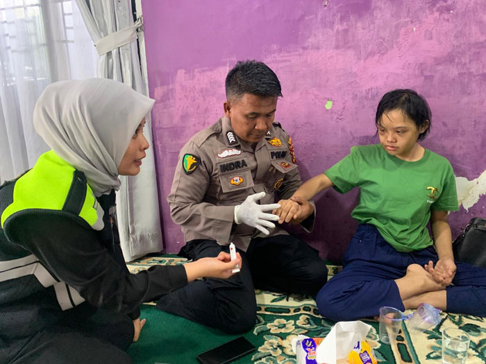 Tim Dokkes Polres Kampar memberikan pelayanan kesehatan dan pendampingan kepada Valeri Wahid korban KDRT, Kamis (29/5/2025).