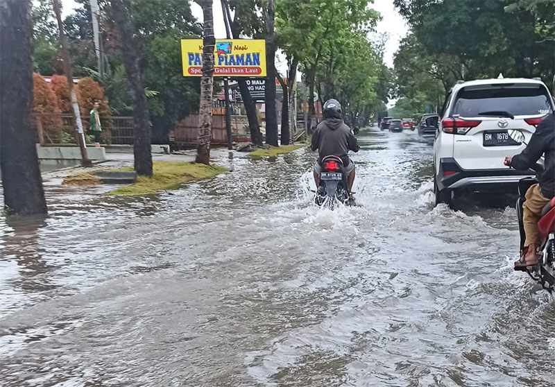 Jalan Arifin Achmad digenangi air hingga menyulitkan kendaraan yang tengah melintas, Sabtu (31/5/2025).