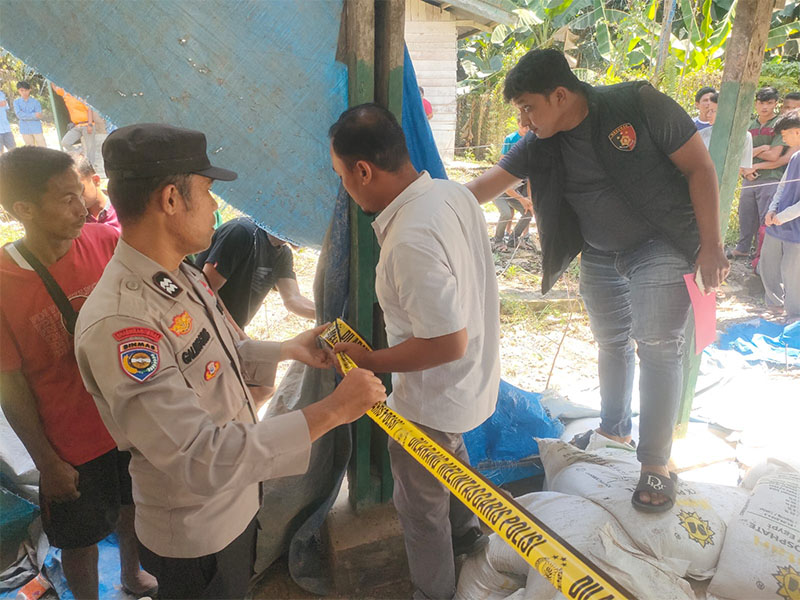 Personil Polsek Langgam memasang police line di gudang parbrik kelapa sawit di Desa Gondai Kecamatan Langgam yang tiba-tiba ambruk dan menyebabkan seorang pekerja tewas, Senin (2/6/2025) siang