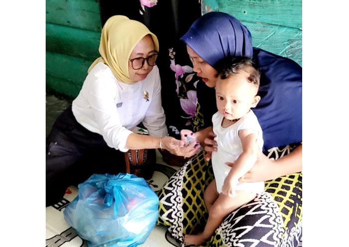 Kepala Dinkes Inhu, Elis Juliarti DCN Mles saat mengunjungi salah seorang pasien KIPI di Kecamatan Lubuk Batu Jaya, Rabu (4/6/2025).