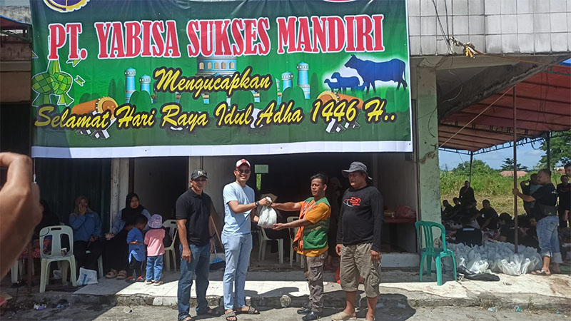 Kepala UPT Perparkiran Dishub Pekanbaru, Radinal Munandar didampingi perwakilan PT Yabisa Iwan Sunadi, memberikan paket daging kurban ke jukir, di Jalan Jendral Sudirman, Sabtu (7/6/2025).