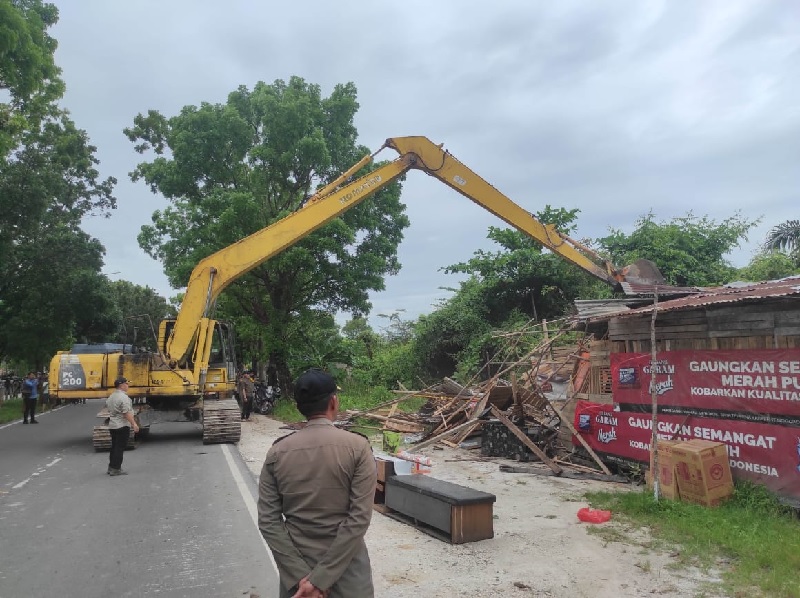 Pembongkaran bangunan liar yang berdiri di atas saluran air  dan diduga tempat prostitusi populer dengan sebutan Tenda Biru oleh Pemko Pekanbaru di kawasan Jalan Sm Amin, Kecamatan Payung Sekaki.