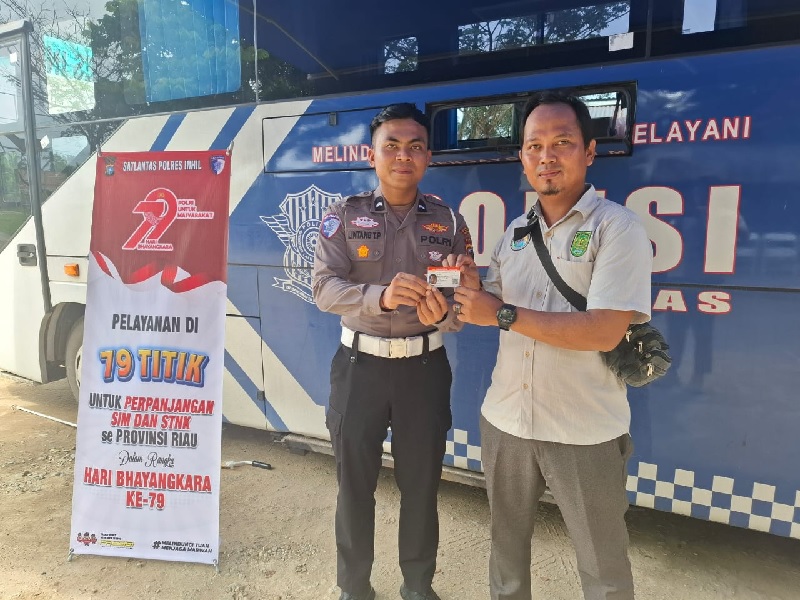 Petugas Satlantas Polres Indragiri Hilir, menyerahkan SIM kepada masyarakat, yang mengikuti program tersebut.