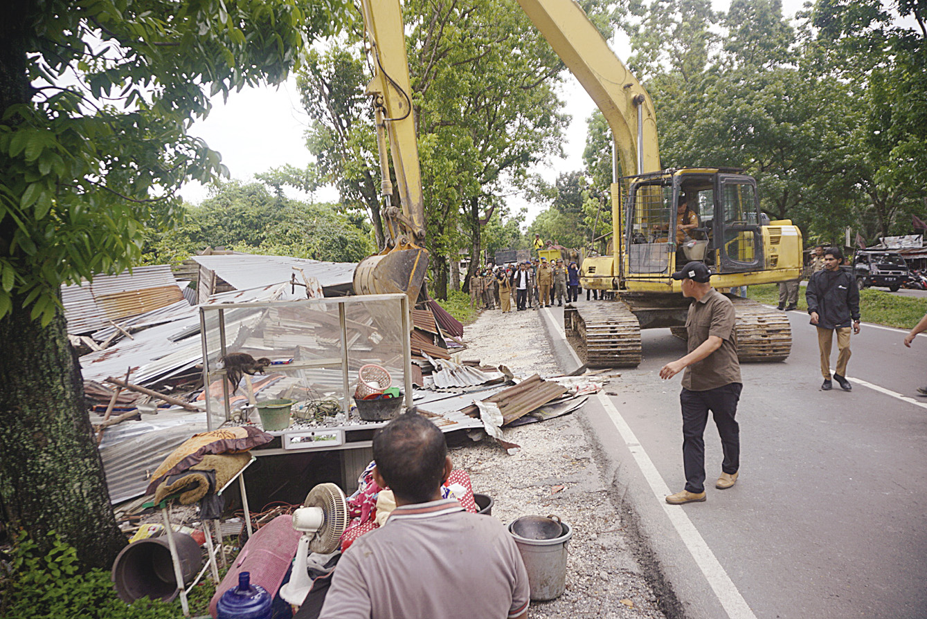 Alat berat membongkar bangunan liar di sepanjang Jalan SM Amin ujung, Kecamatan Payung Sekaki, Selasa (10/6/2025).