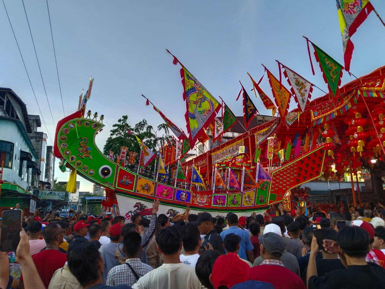 Warga antusias menyaksikan arak-arakan replika tongkang yang akan dibakar, Rabu (11/6/2025).