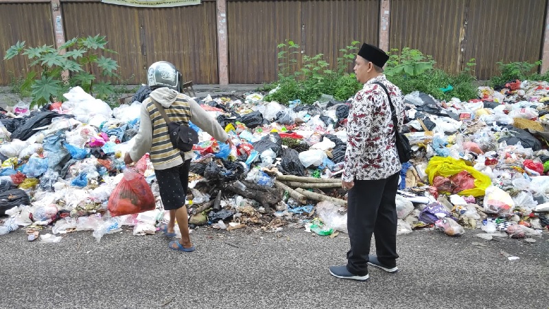 TU SDN 81 Pekanbaru Nopielfariandi menegur warga yang membuang sampah sembarangan di Jalan Gabus, Kelurahan Wonorejo, Kecamatan Marpoyan Damai, Pekanbaru, Kamis (12/6/2025).