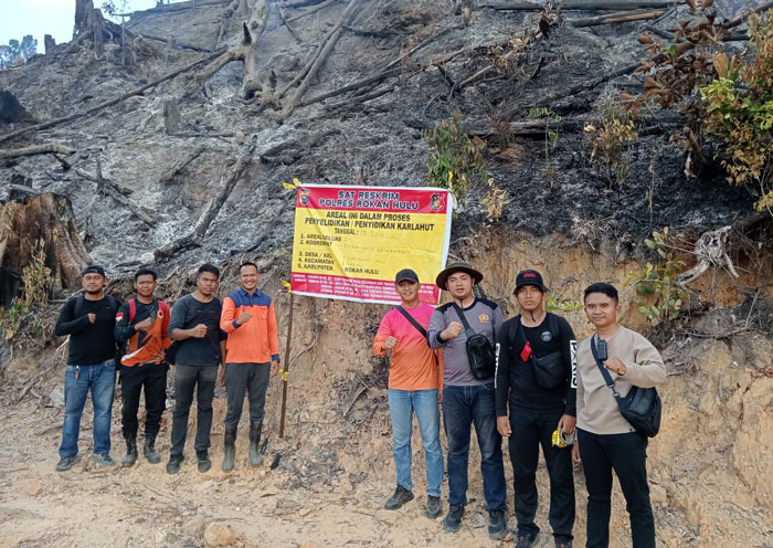Kasat Reskrim Polres Rohul AKP Rejoice Manalu STrK SIK (empat kanan) bersama anggota dan BPBD Rohul memasang plang di areal kawasan hutan terbakar di Desa Sialang Jaya, Rambah, Jumat (13/6/2025).