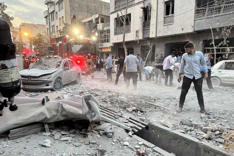 Warga dan petugas tanggap darurat berkumpul di luar gedung yang terkena serangan Israel di Teheran, Iran, Jumat (13/6/2026).