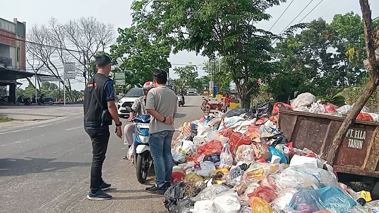 Petugas Dinas Sosial Pekanbaru ikut melakukan penjagaan di TPS, Jalan Paus, Kecamatan Marpoyan Damai untuk melarang warga membuang sampah di luar jam yang telah ditentukan, Jumat (13/6/2025).