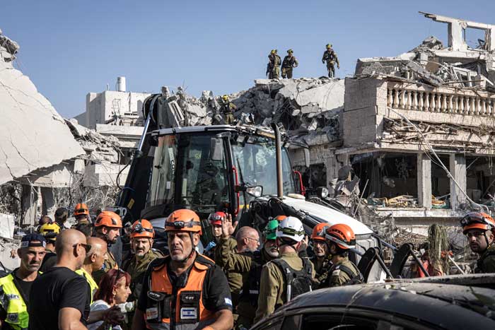 Para petugas Israel mencari korban usai rudal-rudal Iran menghantam Tel Aviv, Sabtu (14/6/2025).