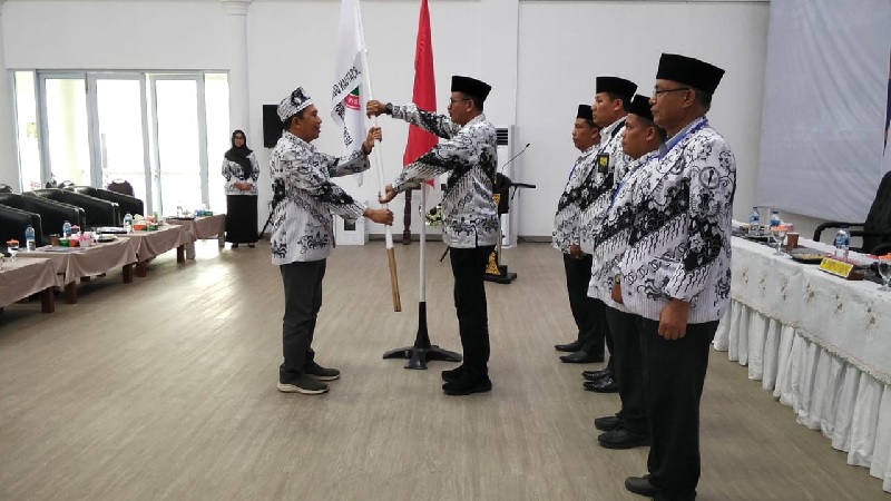 Ketua PGRI Kuansing 2020-2025 Dr Familus MPd menyerahkan bendera PGRI pada Ketua PGRI Kuansing terpilih 2025-2030, H Herizon SPd SD MM dalam Konfercab VI PGRI Kuansing di Pendopo Rumah Dinas Bupati,