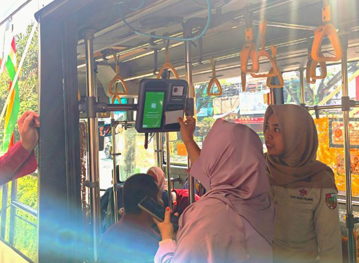 Seorang penumpang bus Transmetro Pekanbaru melakukan pembayaran secara digital saat menikmati moda transportasi publik milik Pemko Pekanbaru, Rabu (18/6/2025).