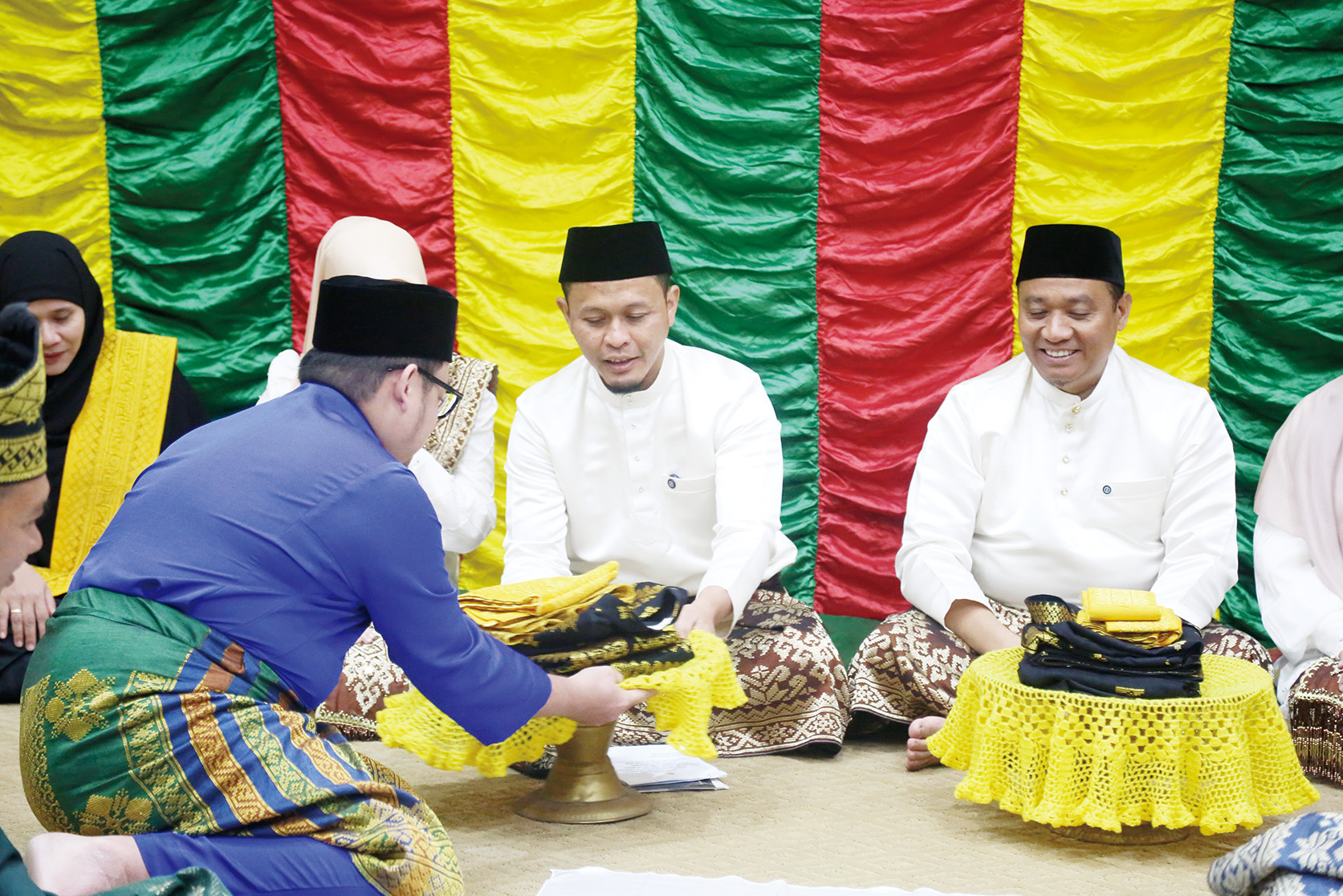 Ketua Umum MKA LAMR Kota Pekanbaru Datuk Rizky Bagus Oka menyerahkan baju adat kepada Wali Kota Pekanbaru Agung Nugroho dan Wakil Wali Kota Pekanbaru Markarius Anwar yang akan dipakai saat penabalan gelar adat, Jumat (20/6/2025) hari ini.