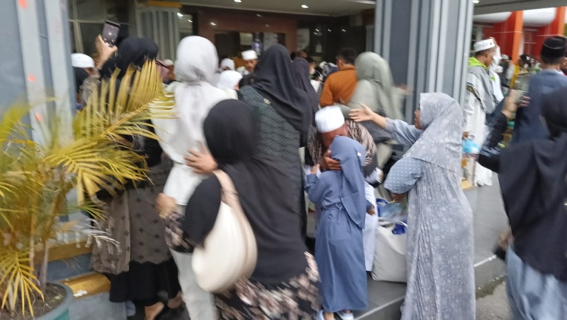 Salah jemaah haji mencium cucunya saat acara penyambutan di halaman Kantor Bupati Inhu, Jumat (20/6/2025)