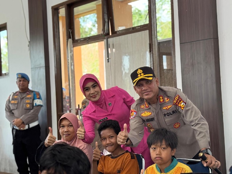 Kapolres Eka dan Ketua Bhayangkari Cabang Siak Eka Priyanti foto bersama peserta sunatan massal di Gedung Endra Dharma Laksana, Mapolres Siak, Sabtu (21/6/2025).