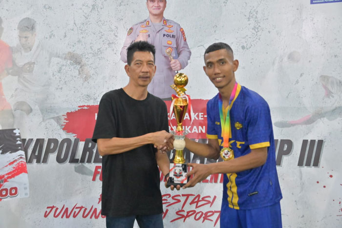 Staf Ahli Bupati Bidang Kemasyarakatan dan SDM Johansyah Syafri menyerahkan piala kepada Tim Futsal Eight Brother di Lapangan Futsal Kybon Kelapa Pati Tengah, Sabtu (20/6/2025).