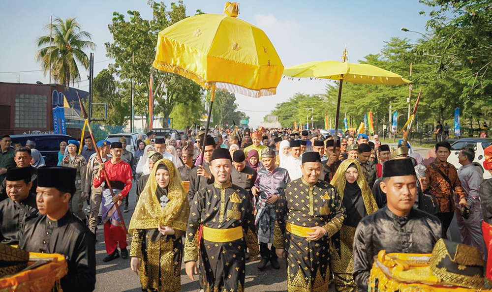 Wako Pekanbaru Agung Nugroho didampingi sang istri Sulastri dan Wawako Pekanbaru Markarius Anwar didampingi sang istri Sari Rahmawati diiringi ribuan masyarakat Pekanbaru berjalan menuju LAMR Pekanbaru untuk mengikuti penabalan gelar adat, Jumat (20/6/202
