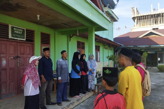 Kepala MTs YPPI Bengkaliss Jumillia menyampaikan arahan kepada siswa saat pengambilan rapat semester genap di depan Kantor MTs YPPI Bengkalis.