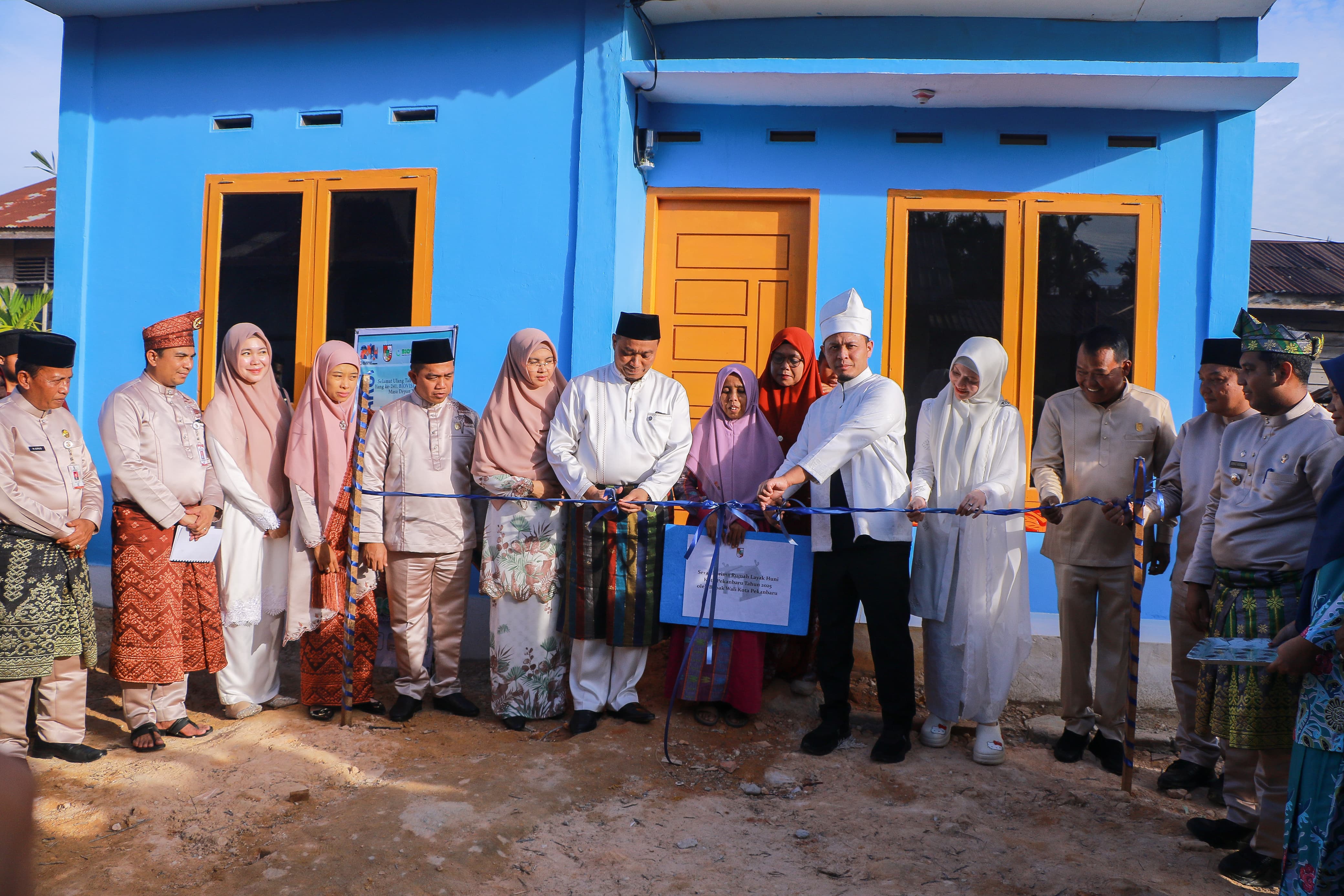 : Wali Kota Pekanbaru Agung Nugroho didampingi Wakil Wali Kota Markarius Anwar memotong pita saat menyerahkan rumah layak huni kepada Irda, warga Jalan Duyung, Kelurahan Sri Meranti, Pekanbaru
