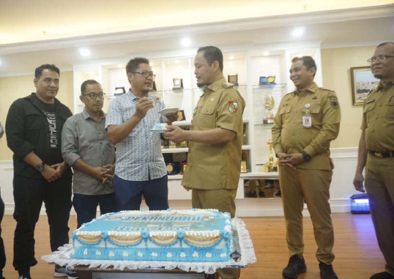Direktur Utama Riau Pos Group Ahmad Dardiri menyuapkan kue ulang tahun HUT ke-241 Pekanbaru kepada Wali Kota Agung Nugroho.