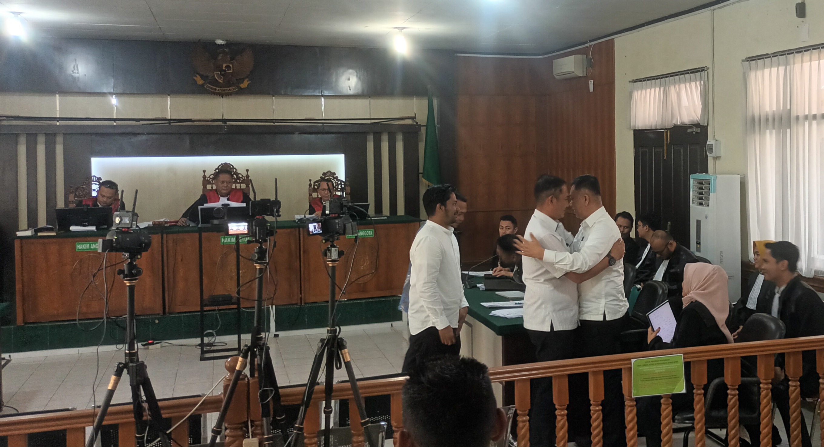 Mantan Kepala Bapenda Pekanbaru alek Kurniawan memeluk mantan Sekko Pekanbaru Indra Pomi nasution (kanan) usai memberikan kesaksian pada sidang korupsi di PN Pekanbaru, Selasa (24/6/2025)