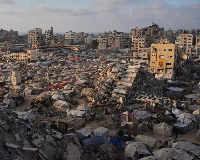 Kamp tenda bagi warga Palestina yang mengungsi membentang di antara puing-puing bangunan yang hancur akibat serangan udara Israel di bagian barat Kota Gaza, Sabtu (21/6/2025).