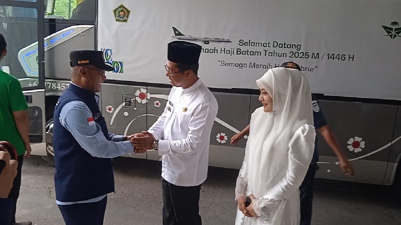 Wabup Rohil Jhony Charles didampingi istri Indah bersalaman dengan Ketua TPHD Rohil Fauzi Efrizal pada saat menyambut kepulangan jemaah haji Rohil yang tiba di Batam, Jumat (27/7/2025) siang.