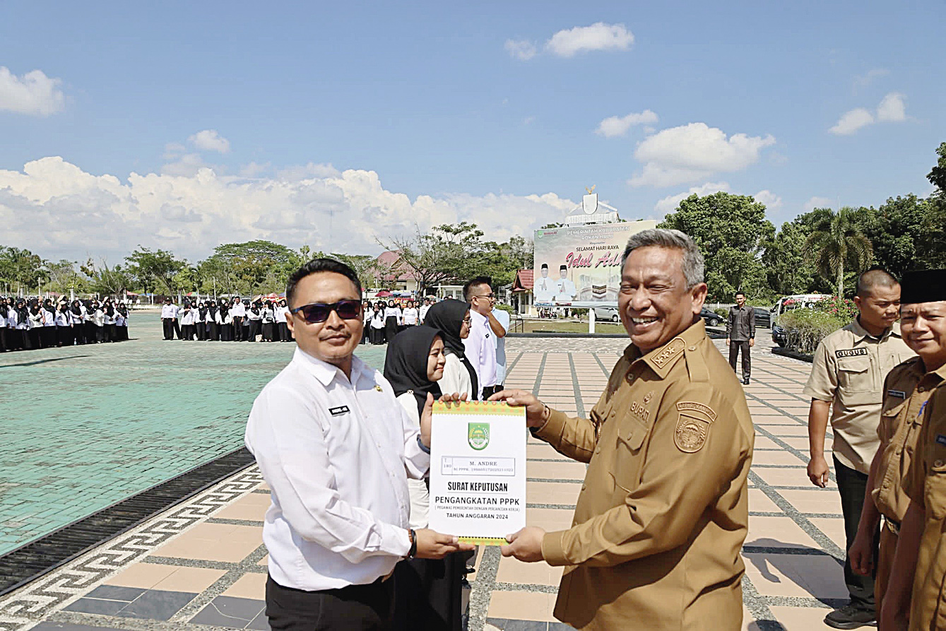 Bupati Rohul Anton ST MM secara simbolis menyerahkan SK pengangkatan PPPK tahap I Rohul tahun 2024 di halaman Kantor Bupati Rohul, Senin (30/6/2025)