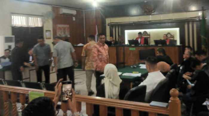 Para saksi perkara korupsi Risnandar Mahiwa, Indra Pomi dan Novin Karmila, kembali ke tempat duduk usai pengambilan sumpah di ruang sidang Pengadilan Tipikor Pekanbaru pada Selasa (1/7/2025).