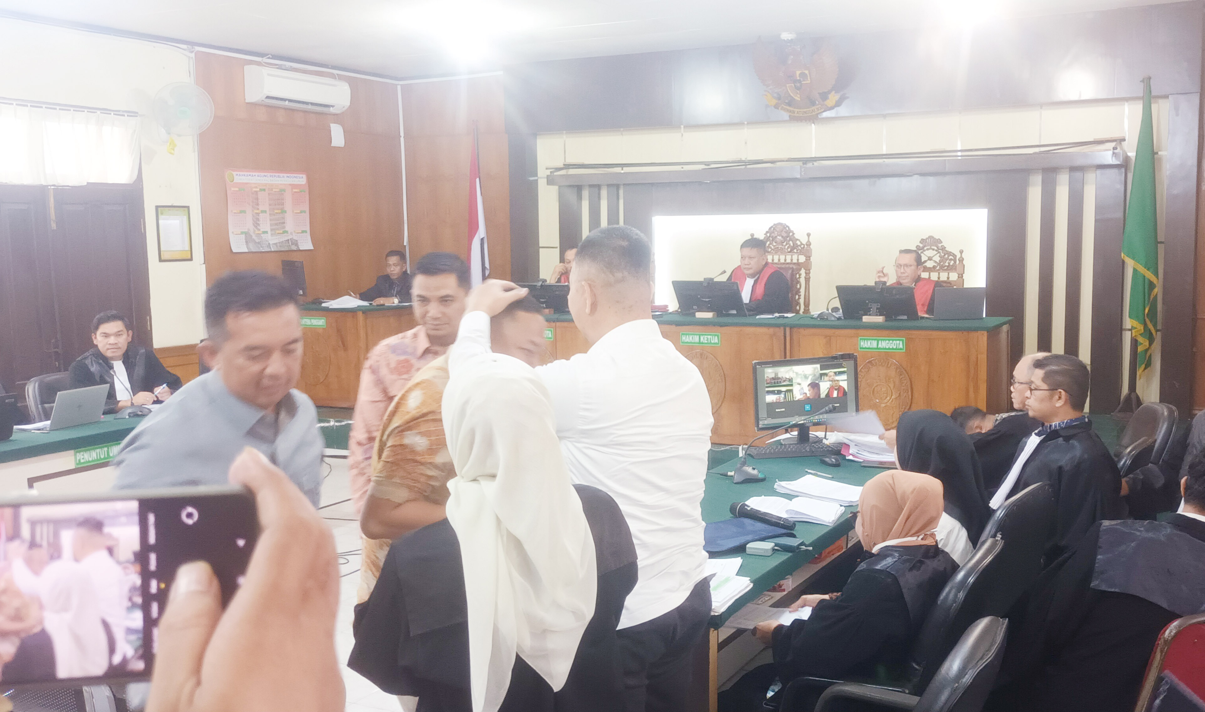 Terdakwa korupsi Indra Pomi Nasution (baju putih) memeluk Kabid di Dinas Perkim, Martin Manalouk, pada sidang di Pengadilan Negeri Pekanbaru, Selasa (1/7/2025).