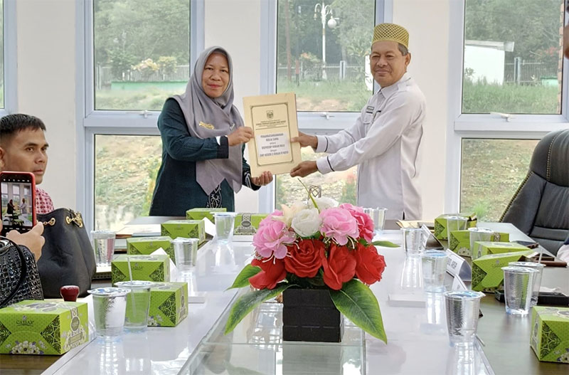 Plt Kepala Dispussip Rohul Sumardi bersama Kepala SMPN 2 Rokan IV Koto Sri Gusni MPd, menunjukkan penandatanganan MoU di ruang rapat Kantor Dispussip Rohul, Rabu (2/7/2025).