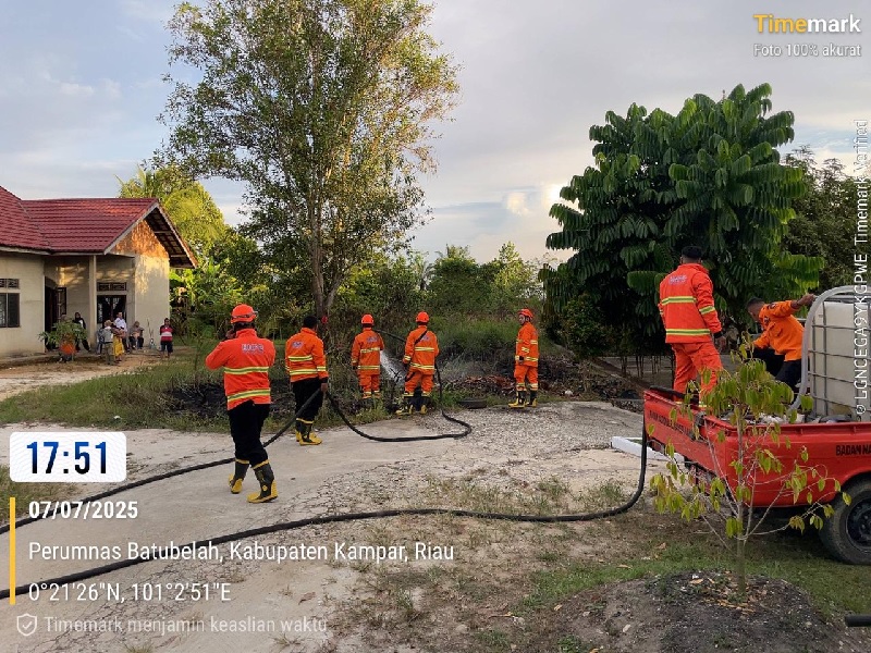 Tim BPBD Kabupaten Kampar memadamkan api yang membakar semak belukar di dedat perumahan Batu Belah, Kecamatan Kampar, Kabupaten Kampar, Senin (7/7/2025).