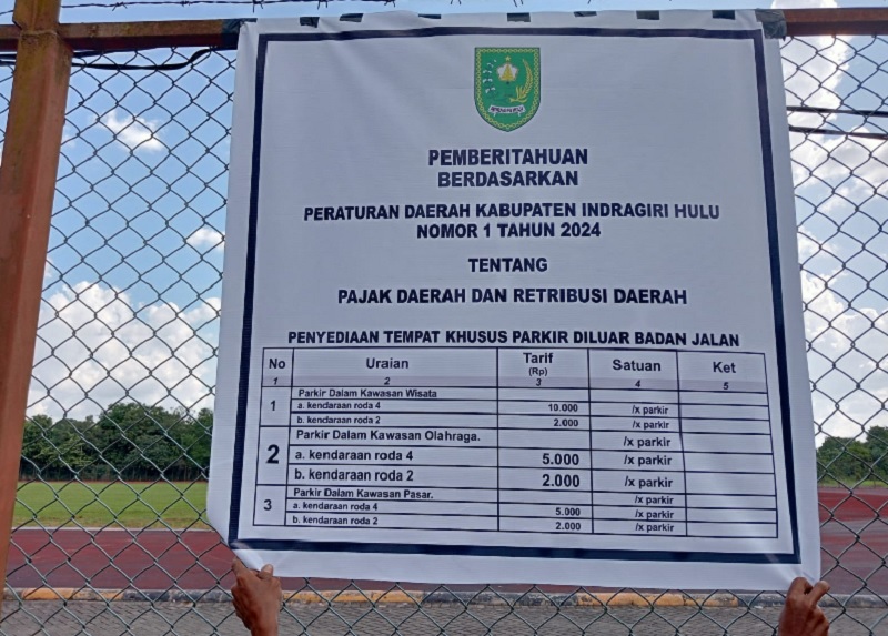Spanduk parkir berbayar yang dipasang di Stadion Batu Canai Kelurahan Pematang Reba Kecamatan Rengat Barat, Senin (7/7/2025)