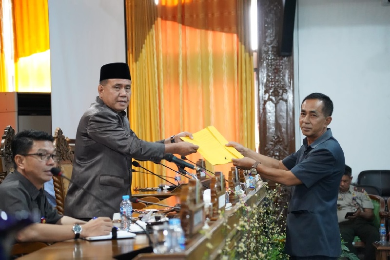 Juru Bicara Fraksi Partai Golkar Endri Yupet SH menyerahkan pandangan umumnya pada Ketua DPRD Kuansing H Juprizal SE MSi dalam paripurna DPRD Kuansing, Selasa (8/7/2025).