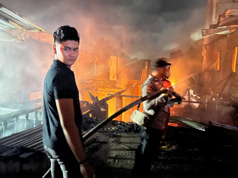 Personel Polsek Pasir Penyu ikut melakukan pemadaman api yang menghanguskan enam unit rumah warga Kelurahan Air Molek I, Selasa (8/7/2025).