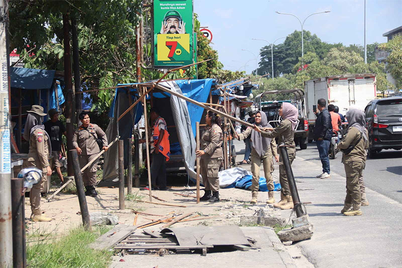 Petugas Satpol PP melakukan penertiban PKL di Jalan Soebrantas Panam Pekanbaru, Kamis (10/7/2025).