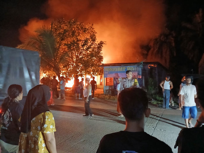 Petugas bersama warga berupaya memadamkan api yang membakar dua unit rumah di Desa Seberida, Rabu (9/7/2025).