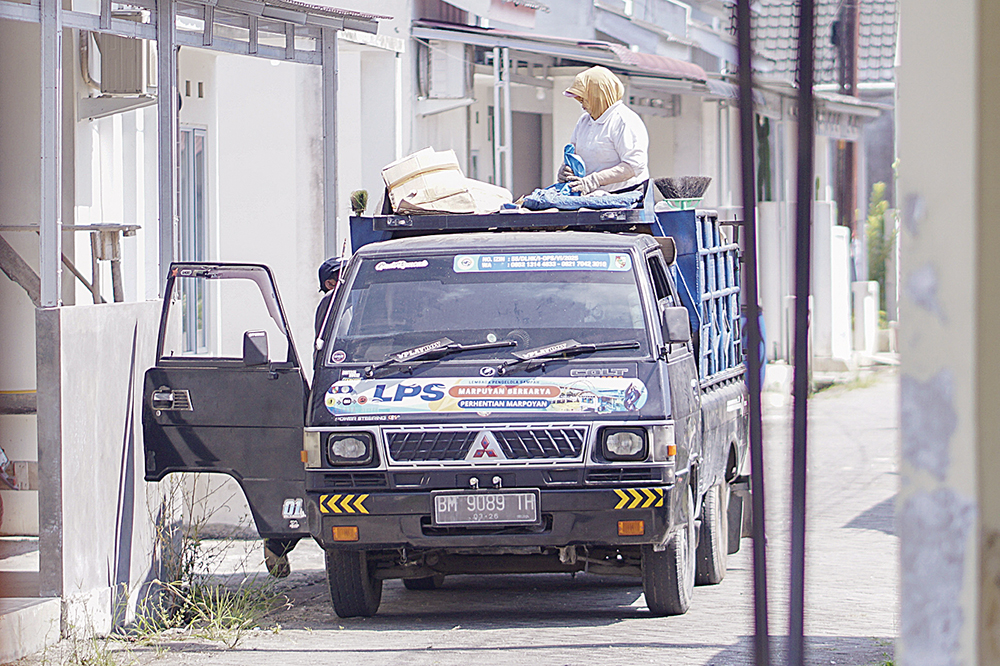 Pekerja yang tergabung kedalam Lembaga Pengelolaan Sampah Kecamatan Marpoyan sedang angkut sampah di pemukiman warga, Pekanbaru, Kamis (10/7/2025)