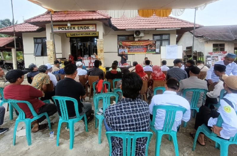 Masyarakat dua Desa di Kecamatan Enok, Inhil sedang menerima materi pemahaman tentang larangan hingga antisipasi pencegahan Karhutla di halaman Mapolsek Enok, Jumat (11/7/2025).