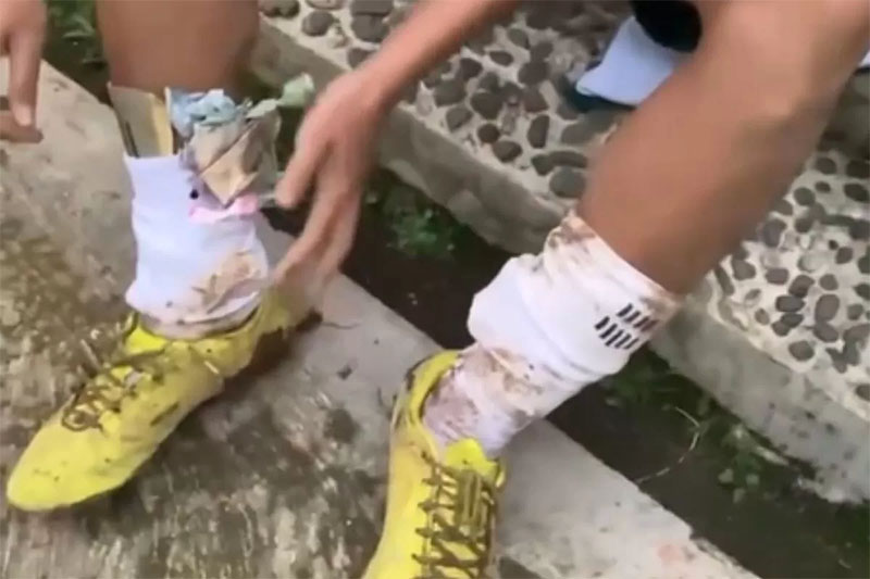 Pemain sepak bola tarkam mengeluarkan saweran dari dalam kaos kaki.