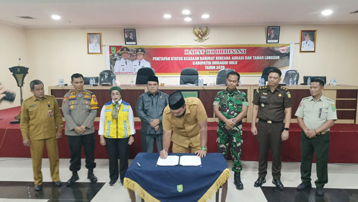 Bupati Inhu Ade Agus Hartanto S.Sos MSI saat menandatangani berita acara penetapan status darurat bencana abrasi dan tanah longsor Kabupaten Inhu 2025, Senin (14/7/2025).