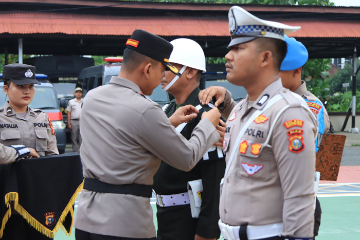 Wakapolres Inhil Kompol Rizki Hidayat menyematkan pita operasi kepada persnoel TNI di halaman Mapolres Inhil, Senin (14/7/2025).