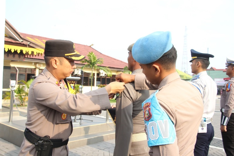 Wakapolres Inhu, Kompol Manapar Situmeang SH SIK MH memasangkan pita kepada perwakilan personil tanda dimulainya Operasi Patuh 2025, Senin (14/7/2025).