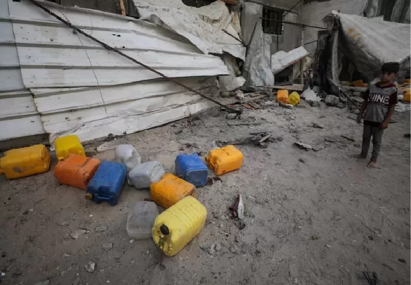 Seorang anak laki-laki Palestina memeriksa lokasi serangan Israel yang menewaskan warga Palestina yang berkumpul untuk mengambil air , Ahad (13/7/2025).