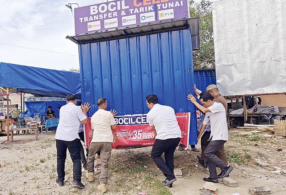 Personel Satpol PP sedang memindahkan tempat usaha PKL yang berjualan di tepi ruas Jalan Diponegoro Pasirpengaraian, baru-baru ini.