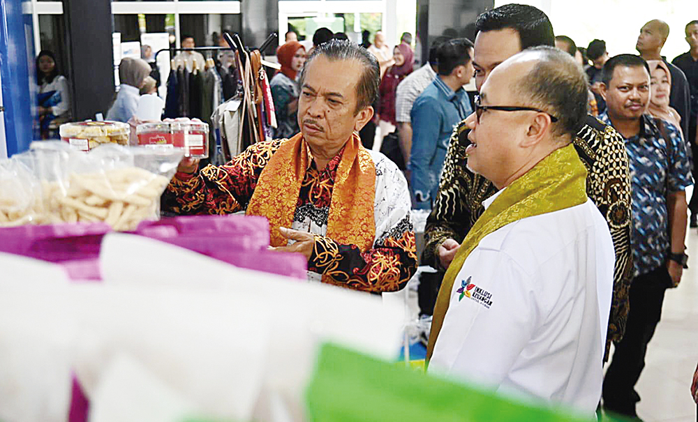 Kepala OJK Provinsi Riau Triyoga Laksito (kanan) didampingi Asisten Perekonomian dan Pembangunan Syahrinaldi saat melihat produk yang dihasilkan pelaku usaha mikro Dumai di sela kegiatan edukasi.