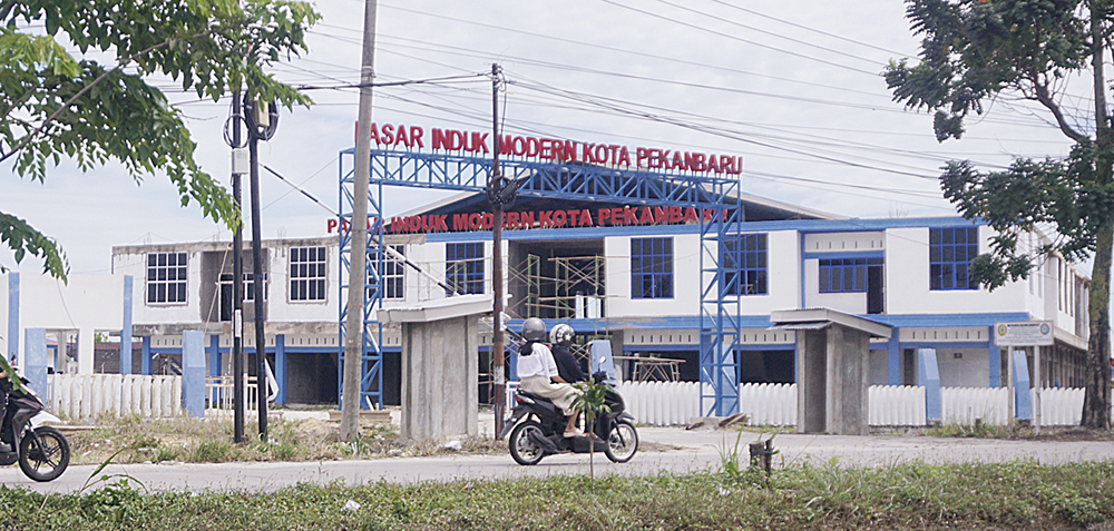 Kendaraan melintas di depan Pasar Induk Moderen Kota Pekanbaru, di Jalan Soekarno-Hatta yang belum selesai pembangunan dan pekerjaan, Pekanbaru, Senin (7/7/2025).